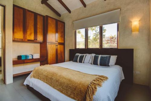 a bedroom with a large bed and a window at Casa Azul - Directly on Playa Venao, sleeps 8-10+ in Playa Venao