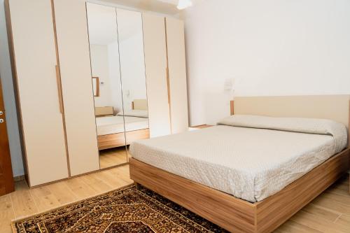a bedroom with a bed and a mirror at Casa di Samu in Bauladu