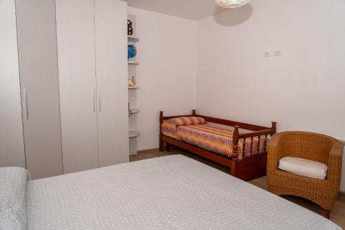 a bedroom with a bed and a couch and a chair at Casa di Samu in Bauladu