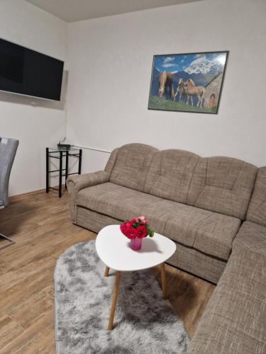 a living room with a couch and a table at apartma-sobe Lejla in Vipava