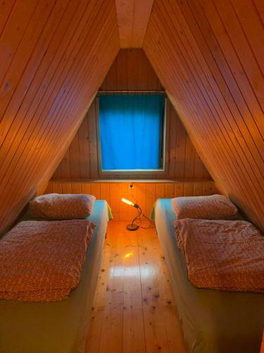 a attic room with two beds and a window at Pszczela Oaza in Bulowiec