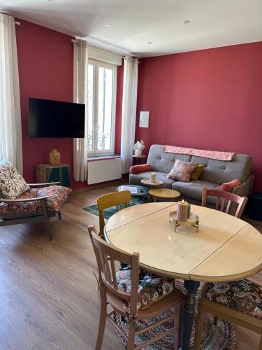 a living room with a couch and a table at L'Écrin des Arts - appartement avec jardin au coeur de la Côte des Blancs in Avize