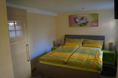 ein Schlafzimmer mit einem Bett und einem Blumengemälde an der Wand in der Unterkunft FeWo Carmen in Wernigerode
