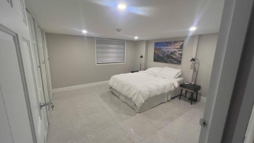a white bedroom with a bed and a window at 1-bedroom One Woodbrook Place Apartment! in Port-of-Spain