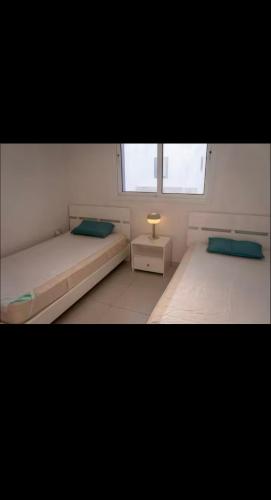 a bedroom with two beds and a lamp in it at MERAKI Villa in Paralimni