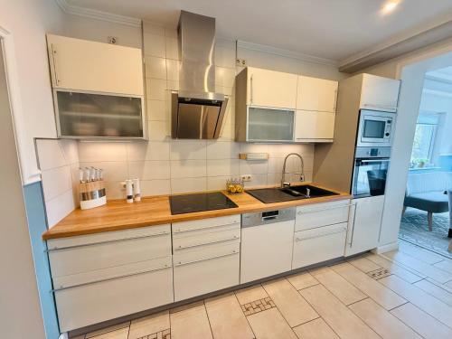 a kitchen with white cabinets and a wooden counter top at Idyllisches Dorfhaus vor Usedom in Gützkow