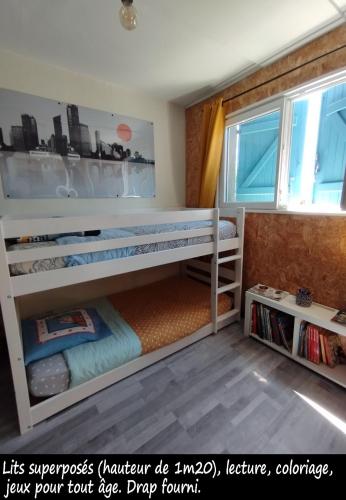 - une chambre pour enfants avec des lits superposés et une fenêtre dans l'établissement Chez Nathalie, à Montauban