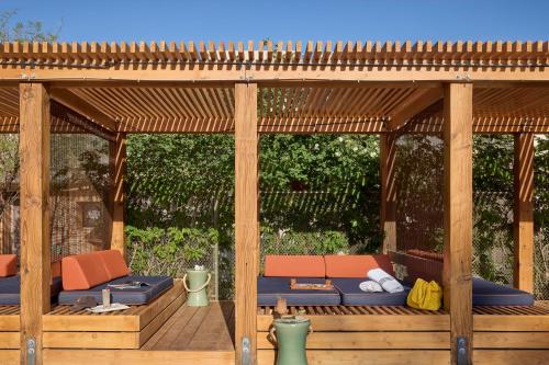 a wooden gazebo with orange and blue chairs at Ace Hotel and Swim Club Palm Springs in Palm Springs
