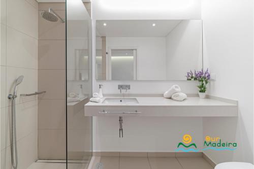 a white bathroom with a sink and a shower at OurMadeira - Calheta Heights, modern in Calheta