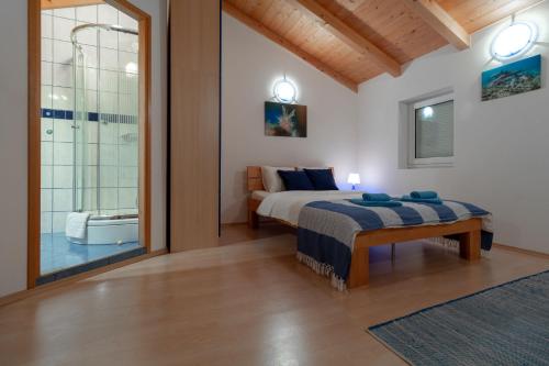 a bedroom with a bed and a bathroom with a tub at House Punat Residence in Punat