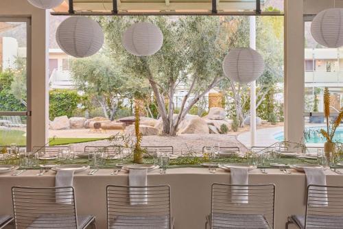 a table set up for a wedding reception with white chairs at Ace Hotel and Swim Club Palm Springs in Palm Springs