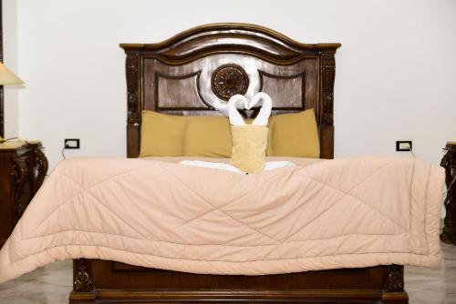 a bedroom with a bed with a wooden headboard at Flamingo Boutique hotels in Luxor