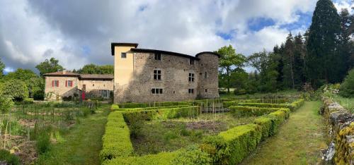 an old stone building with a garden in front of it at Château du Bouy in Champétières