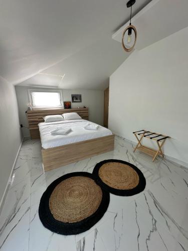 a bedroom with a bed and two rugs on the floor at Fintirik Cozy Stay in Stavros