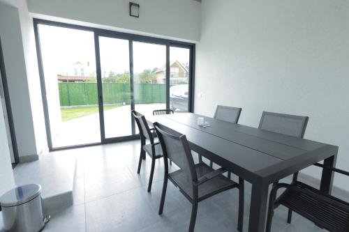 a dining room with a black table and chairs at Danka Pool House in Usije