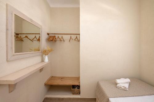 a bedroom with a mirror and a bench in a room at Κυκλαδίτικο studio στα Κιόνια in Kionia