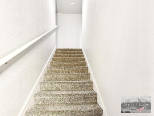 a staircase in a white room with a picture on the wall at Boho Revival Modern Glam with AC in Downtown Albany in Albany