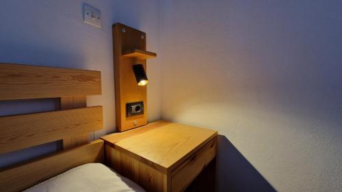 a small room with a bed and a night stand at Freesia House in Kranidi