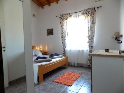 a bedroom with a bed and a window at Freesia House in Kranidi