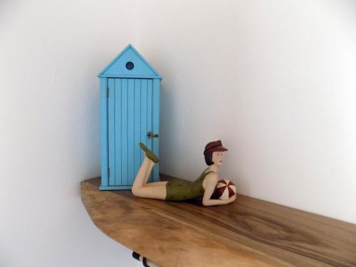 a doll sitting on a shelf next to a blue door at Freesia House in Kranidi