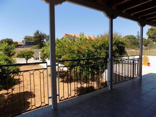 a screened porch with a fence and trees at Freesia House in Kranidi