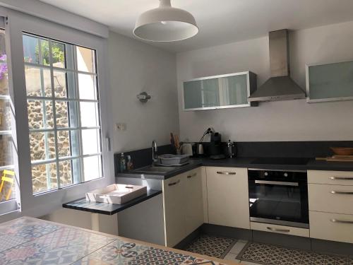 une cuisine avec un évier et une cuisinière four supérieur dans l'établissement LA CHAPELLE, à Saint-Quay-Portrieux