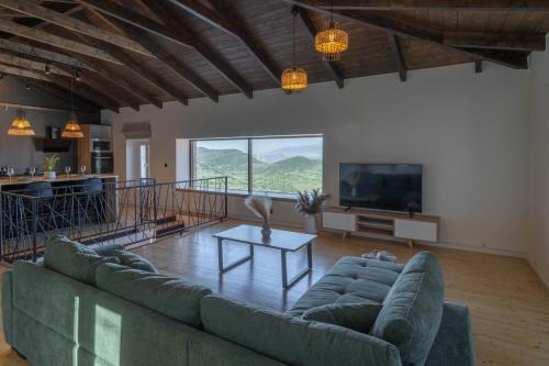 a living room with a couch and a tv at Amalia Casa Lefkada in Pigadhisánoi