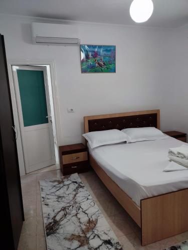 1 dormitorio con cama y puerta con espejo en Guest house Eloid, en Berat