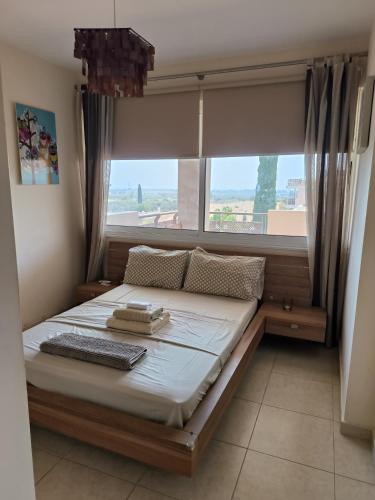 a bed in a room with a large window at Superior 1 bed apartment in Oroklini with Communal Pool in Voroklini