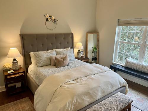 a bedroom with a large bed and two windows at 6BR Modern Farmhouse Retreat in Franklin