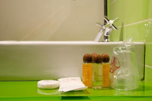 a bathroom with a sink and a green counter with medicines at Ciudad de Alcala in Alcalá de Henares