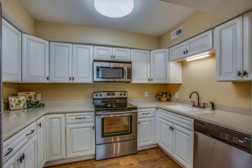 a kitchen with white cabinets and stainless steel appliances at 6BR Modern Farmhouse Retreat in Franklin