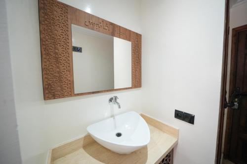 a bathroom with a sink and a mirror on the wall at Dar Al Fanouss in Rabat