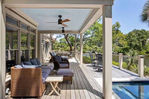 a covered deck with furniture and a swimming pool at 735 Virginia Rail Road by Akers Ellis Rentals in Kiawah Island