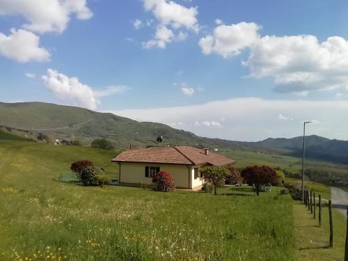 a small house in a field with mountains in the background at Agriturismo Bordigaie in Bruscoli