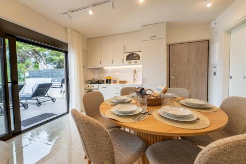 une cuisine et une salle à manger avec une table et des chaises en bois dans l'établissement Villa Episkopos Seaside, à Nikiana