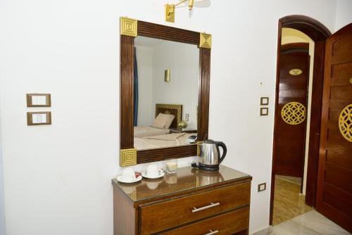 a mirror on a dresser next to a bedroom at Flamingo Boutique hotels in Luxor