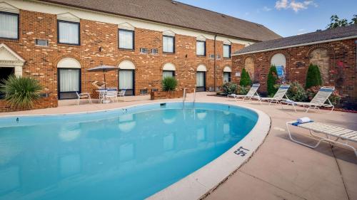 a large swimming pool in front of a brick building at Best Western PLUS Governor's Inn Richmond in Midlothian