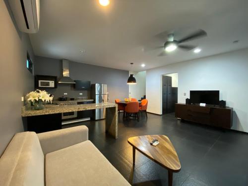 una sala de estar con un sofá y una mesa en Sole Suites, en Playa del Carmen