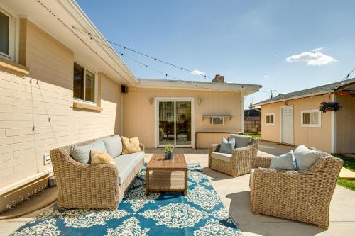 a patio with wicker chairs and a couch and a table at Near Shops and Eats Elegant Home in Wheat Ridge! in Wheat Ridge