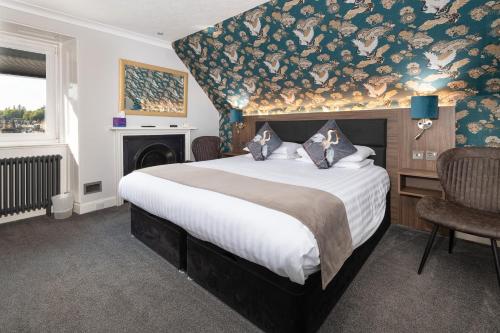 a bedroom with a large bed with a floral wall at Atholl Villa Guest House in Pitlochry