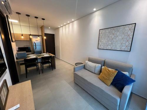 een woonkamer met een bank en een eetkamer bij Edificio Liv P.Verde Apto 1013-Mandi Hospitalidade in Maceió