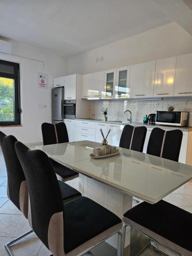 a kitchen with a glass table and black chairs at Apartmani Mariva in Dicmo