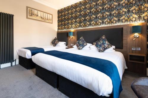 a hotel room with two beds with blue sheets at Atholl Villa Guest House in Pitlochry
