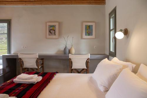 a bedroom with a bed and a table and chairs at Under The Linden Tree Tinos in Xinára