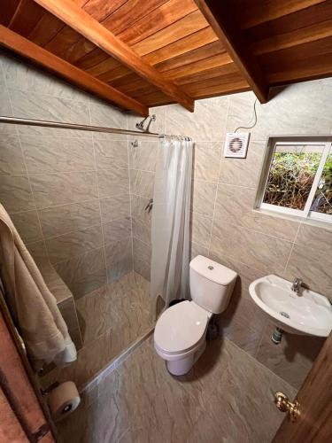 a bathroom with a toilet and a sink at Casa Nutabe - Casa de Campo en Girardota cerca a Medellín in Girardota