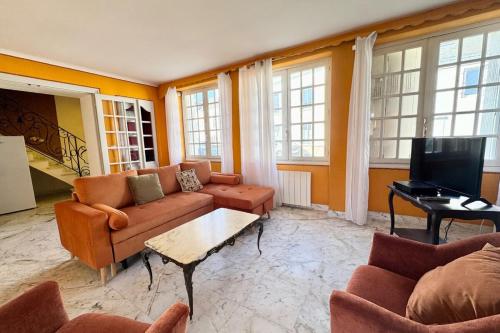 a living room with a couch and a tv at Refuge breton entre mer pierres et jardin in Port-Louis