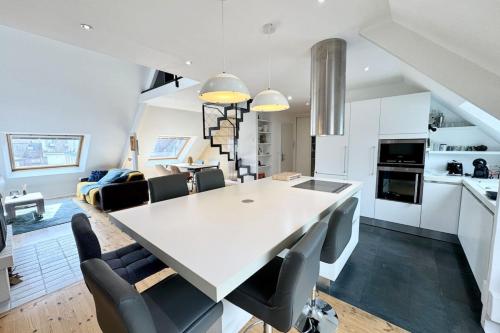 eine Küche und ein Wohnzimmer mit einem weißen Tisch und Stühlen in der Unterkunft Loft contemporain - En plein centre de Lorient in Lorient