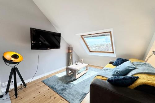 ein Wohnzimmer mit Couch und Flachbildfernseher in der Unterkunft Loft contemporain - En plein centre de Lorient in Lorient