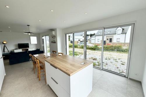 une cuisine et un salon avec une table et des chaises dans l'établissement Maison neuve contemporaine - 10min des plages 2, à Saint-Pierre-Quiberon